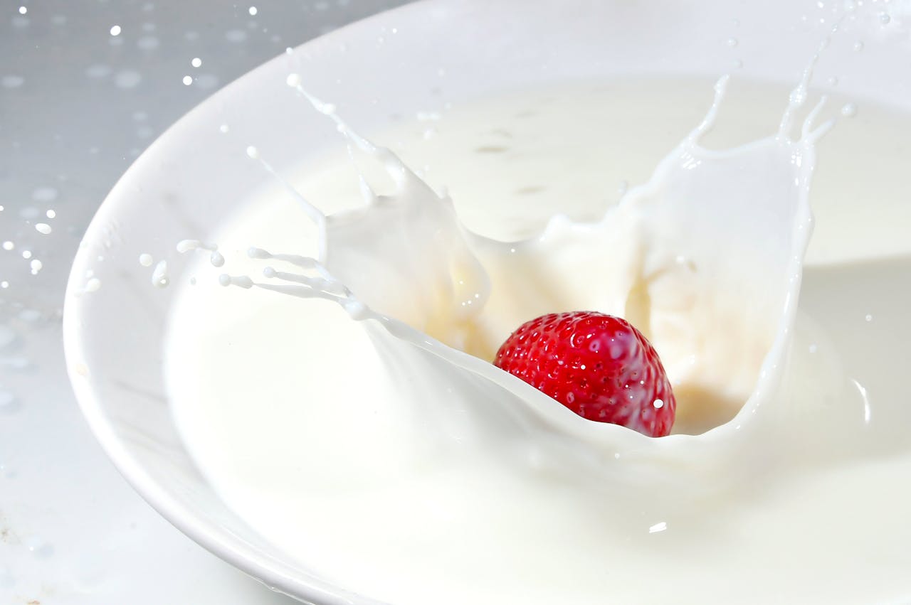 Vibrant strawberry splashing in milk creates a fresh and dynamic visual impact.
